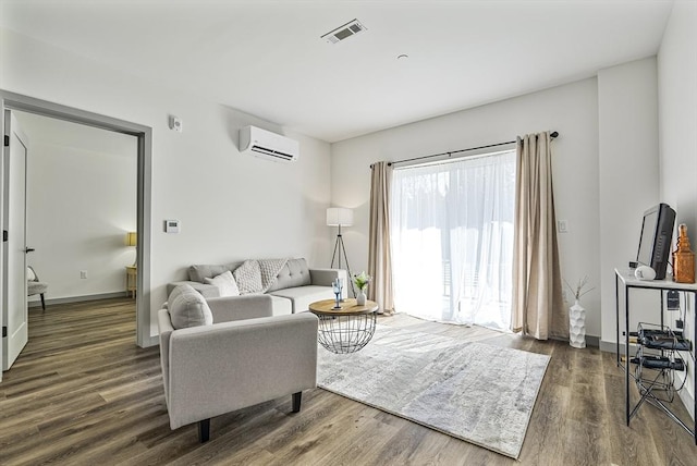 living room featuring baseboards, a wall mounted AC, wood finished floors, and visible vents