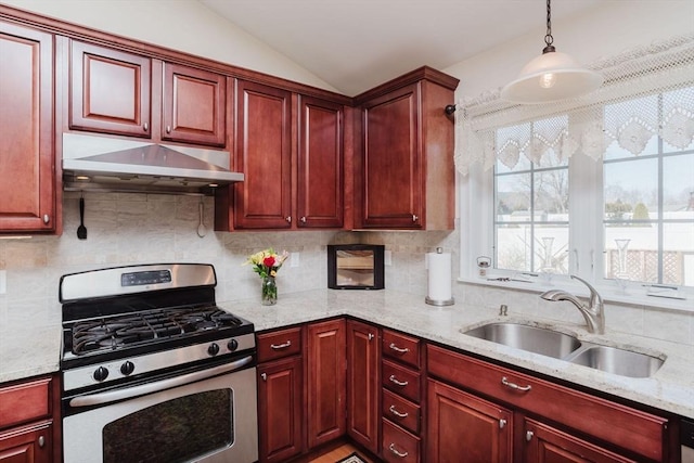 kitchen with reddish brown cabinets, a sink, stainless steel range with gas stovetop, and under cabinet range hood