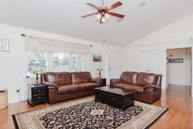 living room featuring lofted ceiling, light wood-style floors, and a ceiling fan