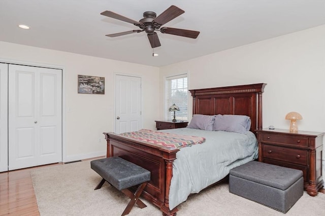 bedroom featuring recessed lighting, a closet, light wood-style flooring, a ceiling fan, and baseboards