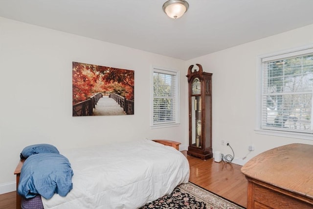 bedroom with baseboards and wood finished floors