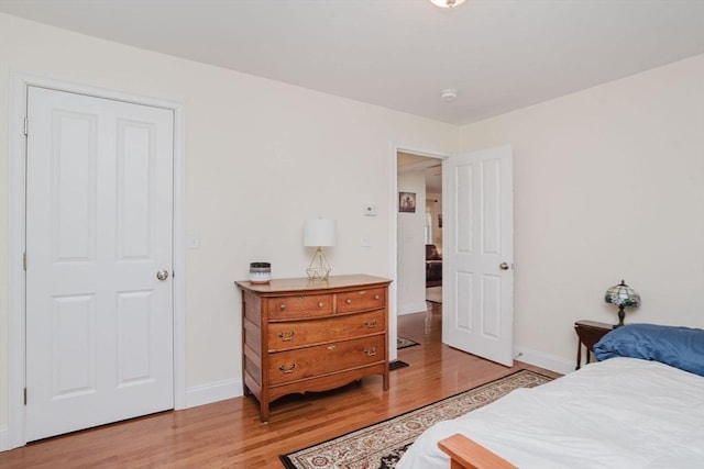 bedroom with light wood-style flooring and baseboards