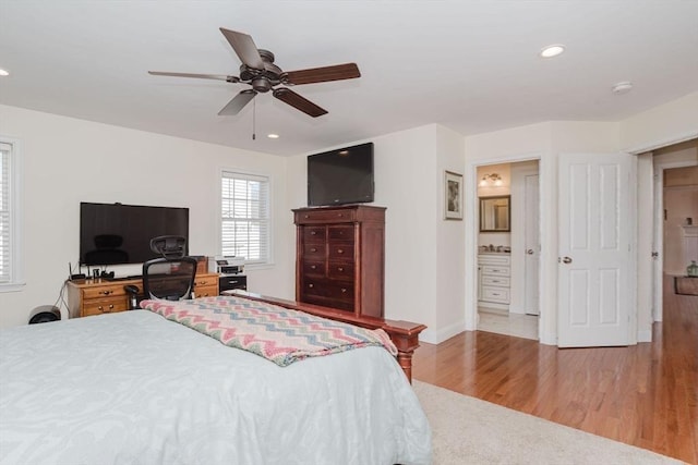 bedroom featuring ceiling fan, recessed lighting, wood finished floors, baseboards, and ensuite bath