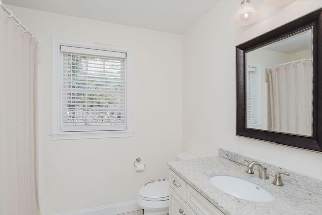 full bathroom with toilet, vanity, and baseboards