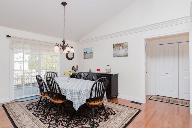 dining space featuring vaulted ceiling, light wood finished floors, a chandelier, and baseboards