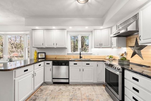 5 Crescent Ln, Sudbury, MA 01776 - kitchen featuring wall chimney range hood, a peninsula, white cabinets, stainless steel appliances, and a sink