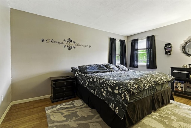 bedroom featuring wood finished floors and baseboards