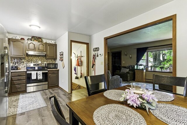 dining room with wood finished floors and a baseboard radiator