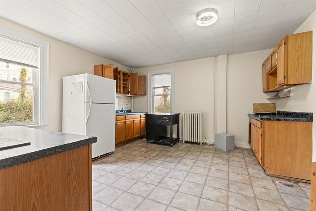 kitchen featuring sink, white fridge, and radiator heating unit