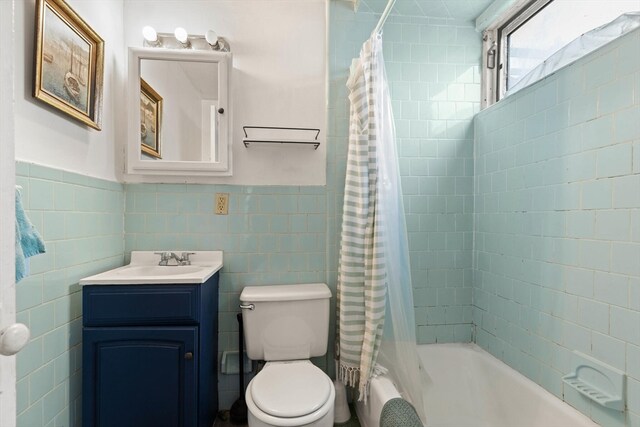 full bathroom featuring vanity, tile walls, toilet, and shower / tub combo with curtain