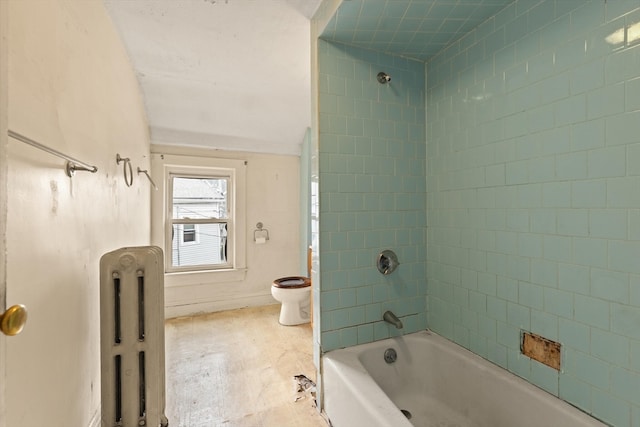 bathroom with tiled shower / bath, toilet, and radiator heating unit