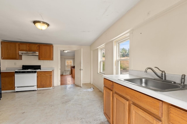 kitchen featuring white stove and sink