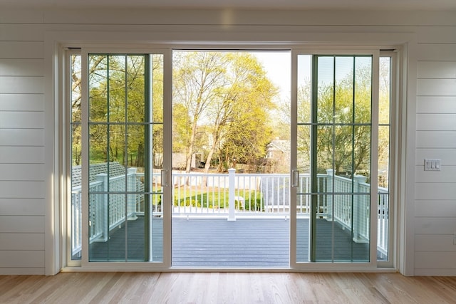 entryway with hardwood / wood-style flooring, wood walls, and a wealth of natural light