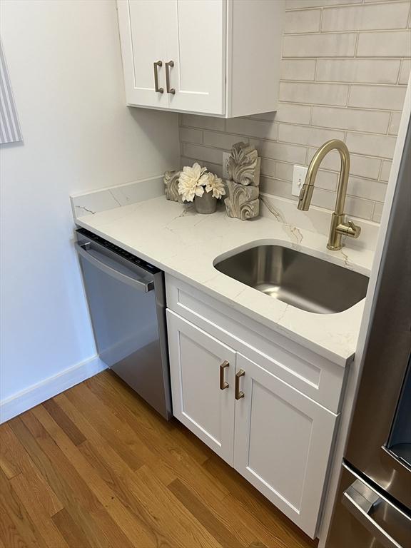 90 Broadway Unit 2C, Boston, MA 02116 - bar area featuring dishwasher, dark wood finished floors, and tasteful backsplash