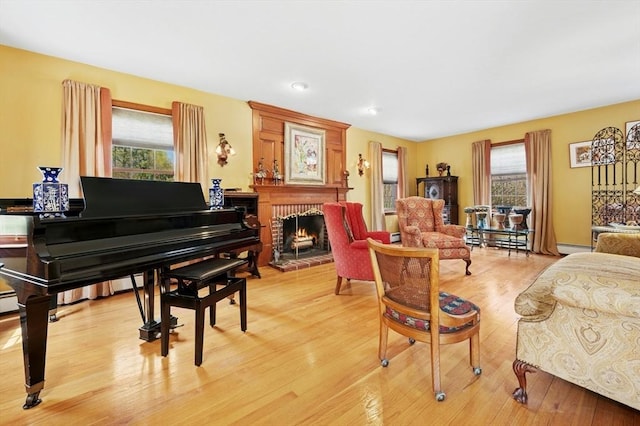 living room with a brick fireplace, a wealth of natural light, and light wood-type flooring