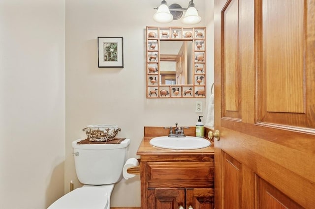half bath with vanity, a notable chandelier, and toilet