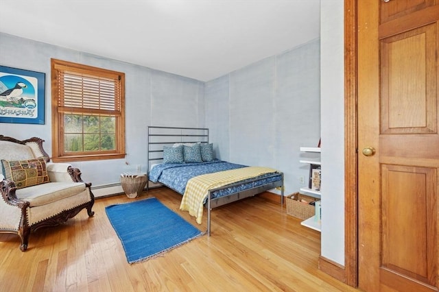 bedroom featuring a baseboard radiator and wood finished floors