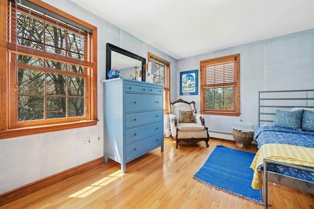 bedroom featuring wood finished floors and a baseboard radiator