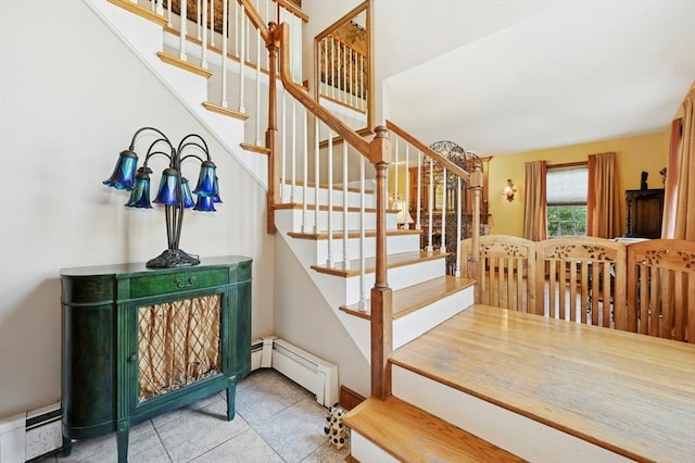 stairs featuring tile patterned floors and a baseboard heating unit
