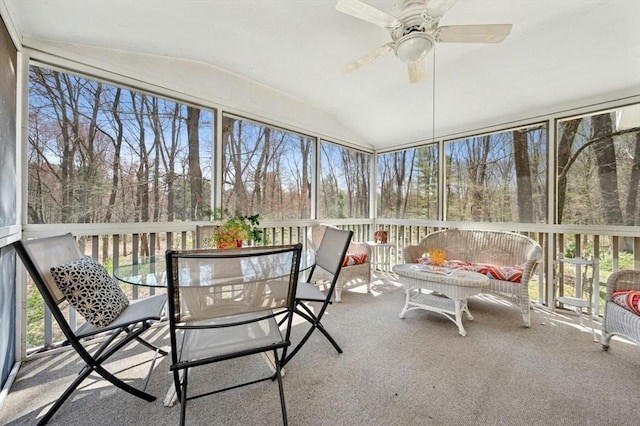 sunroom / solarium with a ceiling fan and outdoor dining space
