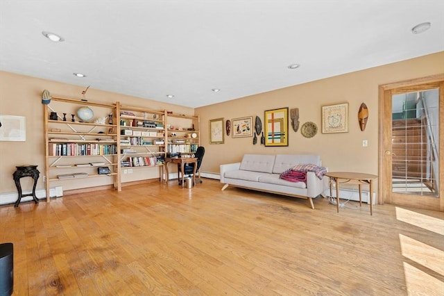 sitting room with recessed lighting, a baseboard heating unit, and wood finished floors