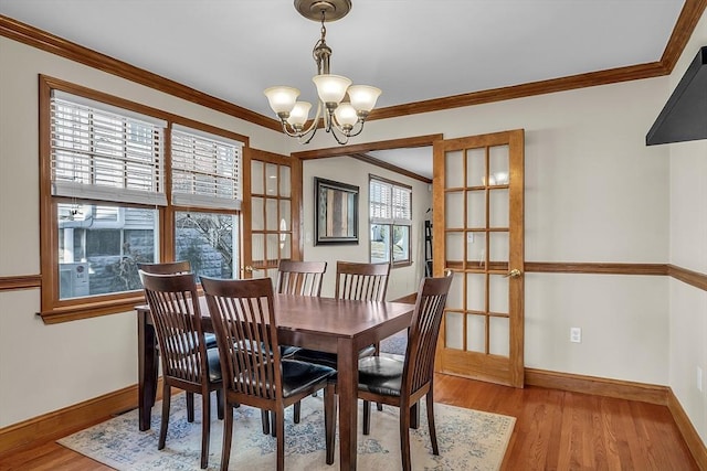 dining room with ornamental molding, a chandelier, and light wood-type flooring