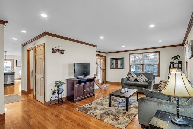 living room with ornamental molding and light wood-type flooring