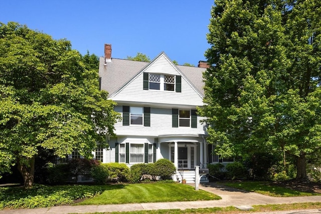 21 Waterston Rd, Newton, MA 02458 - view of front of house featuring a front lawn and a chimney