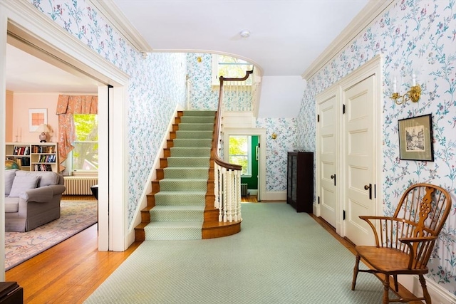 21 Waterston Rd, Newton, MA 02458 - stairway featuring wallpapered walls, radiator heating unit, wood finished floors, crown molding, and baseboards