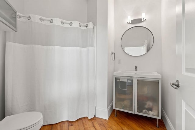 281 Essex St Unit 206, Salem, MA 01970 - bathroom featuring wood finished floors, toilet, a sink, baseboards, and a shower with curtain