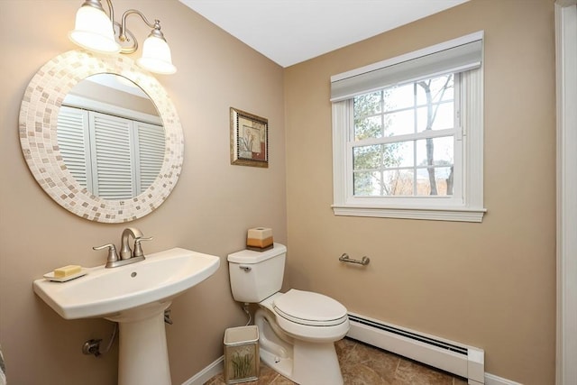 bathroom with a baseboard heating unit, baseboards, and toilet