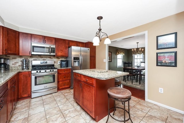 kitchen with a breakfast bar, decorative backsplash, stainless steel appliances, and light stone countertops