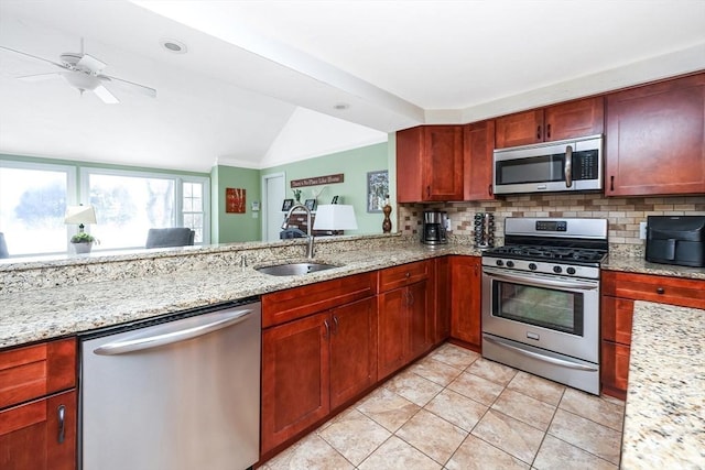 kitchen with a sink, light stone countertops, backsplash, and appliances with stainless steel finishes