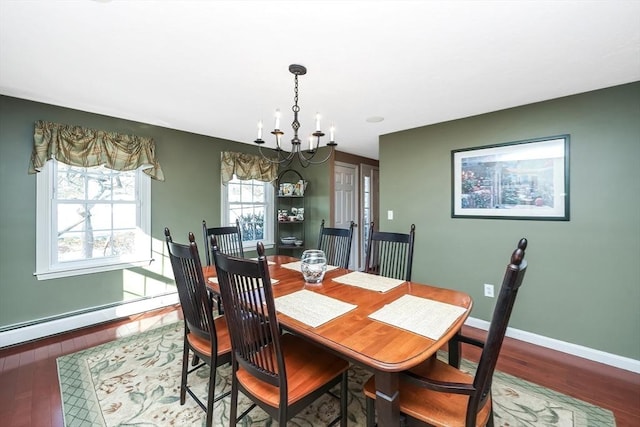 dining area with a baseboard heating unit, a notable chandelier, wood finished floors, and baseboards