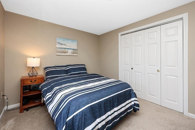 bedroom with a closet, baseboards, and carpet