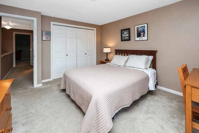 carpeted bedroom featuring attic access, baseboards, and a closet