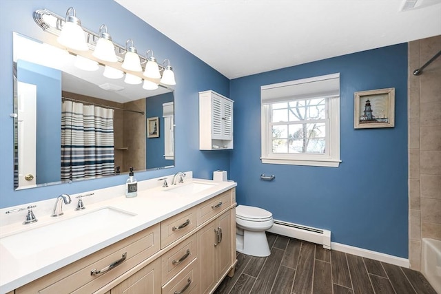 bathroom featuring a sink, a baseboard radiator, wood finish floors, and toilet