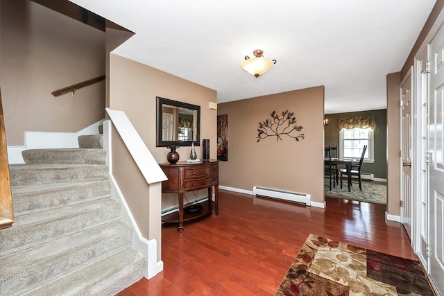 stairs with a baseboard radiator, baseboards, and wood finished floors