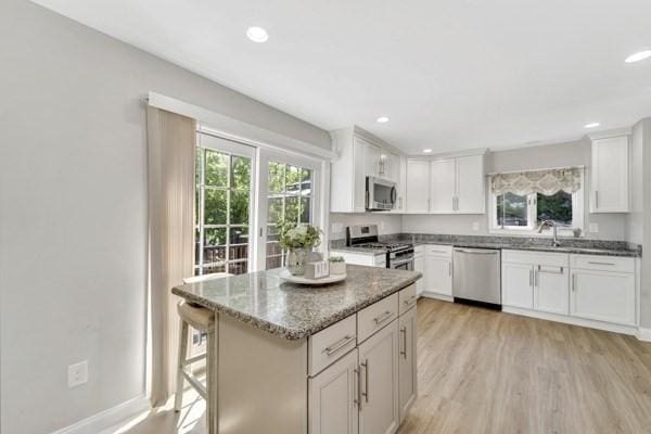 135 Pine Grove Ave, Lynn, MA 01904 - kitchen with appliances with stainless steel finishes, stone countertops, light wood-style floors, white cabinets, and recessed lighting