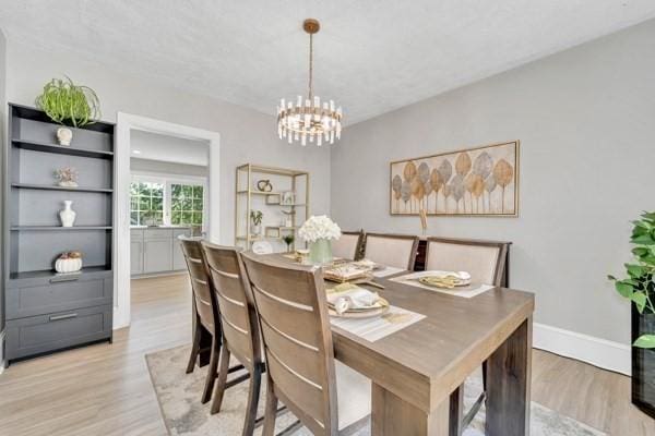 135 Pine Grove Ave, Lynn, MA 01904 - dining space with light wood-style flooring, a chandelier, and baseboards