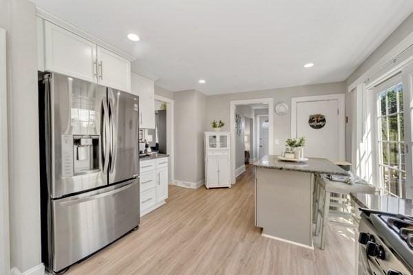 135 Pine Grove Ave, Lynn, MA 01904 - kitchen with stainless steel appliances, light wood-type flooring, white cabinets, a center island, and baseboards