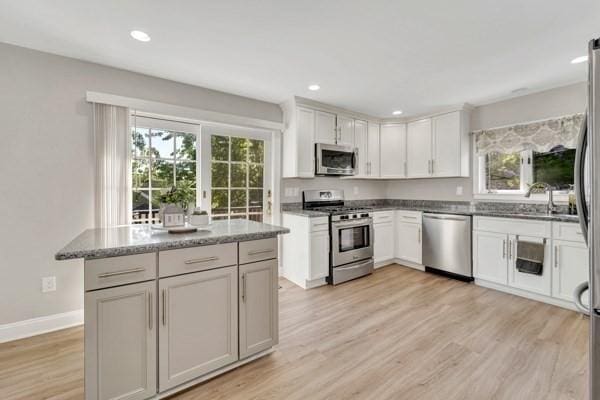 135 Pine Grove Ave, Lynn, MA 01904 - kitchen with appliances with stainless steel finishes, light wood-type flooring, a sink, recessed lighting, and stone counters