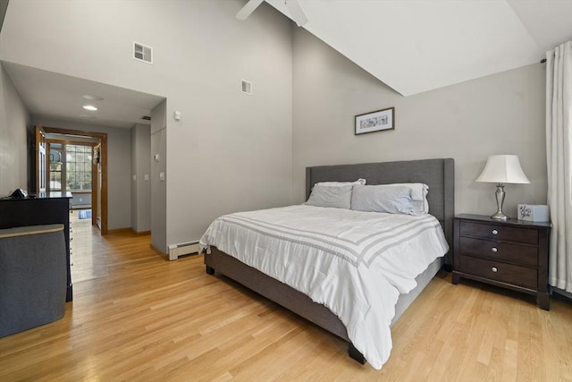 bedroom featuring baseboards, visible vents, light wood finished floors, and a baseboard radiator