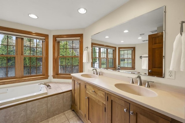 bathroom featuring a garden tub, recessed lighting, tile patterned flooring, and a sink