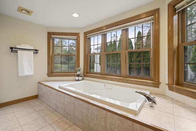 bathroom featuring tile patterned floors, baseboards, a wealth of natural light, and a garden tub