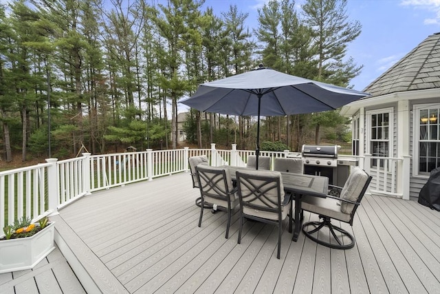 wooden deck featuring outdoor dining space and a grill
