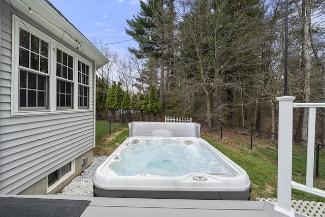 exterior space with fence, a lawn, and an outdoor hot tub