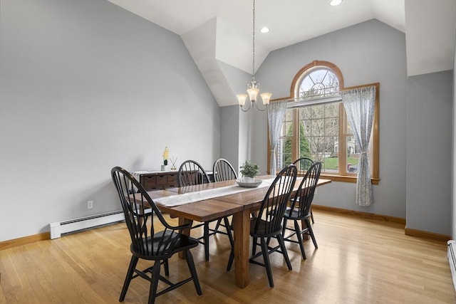 dining area with lofted ceiling, a chandelier, light wood-style flooring, and a baseboard heating unit