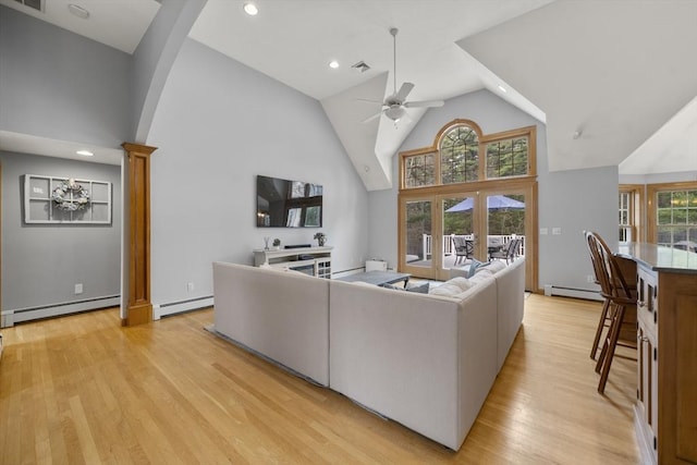 living area with a baseboard radiator, visible vents, a ceiling fan, and light wood-style floors
