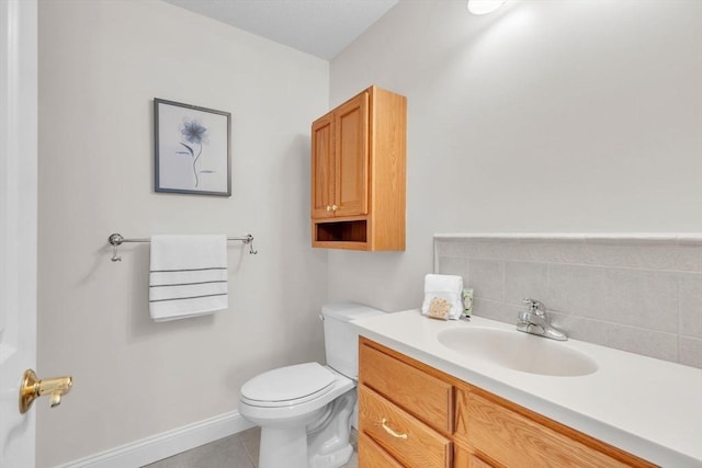 bathroom featuring toilet, vanity, and tile patterned flooring